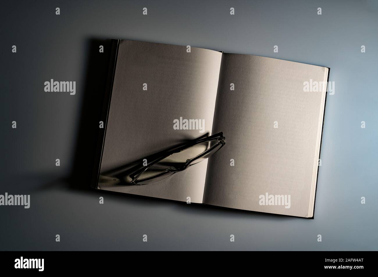 a pair of glasses on the blank pages of a book Stock Photo