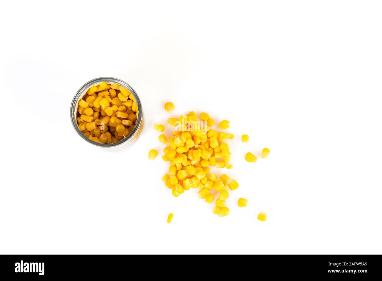 a tin of corn spilled on a white surface Stock Photo