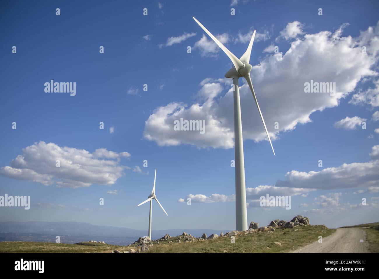 View of a wind turbines on top of mountains, cloudy sky as background ...
