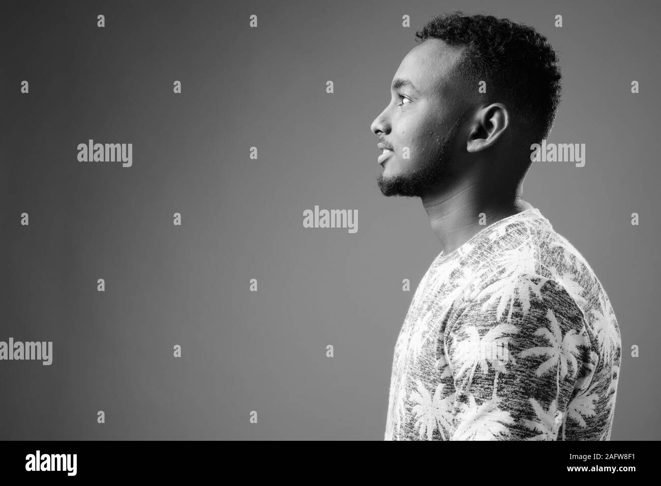 Young handsome African man against gray background Stock Photo