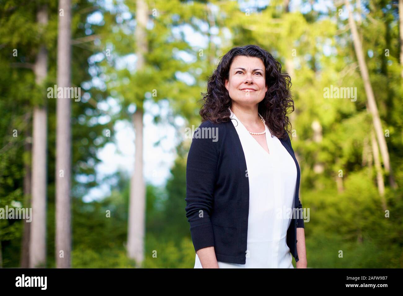 Portrait confident, serene woman in woods Stock Photo