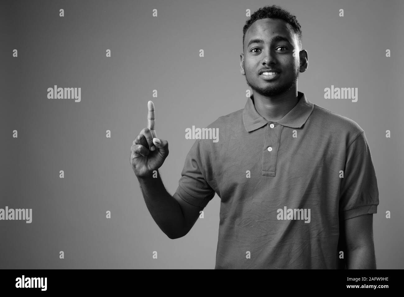 Young handsome African man against gray background Stock Photo