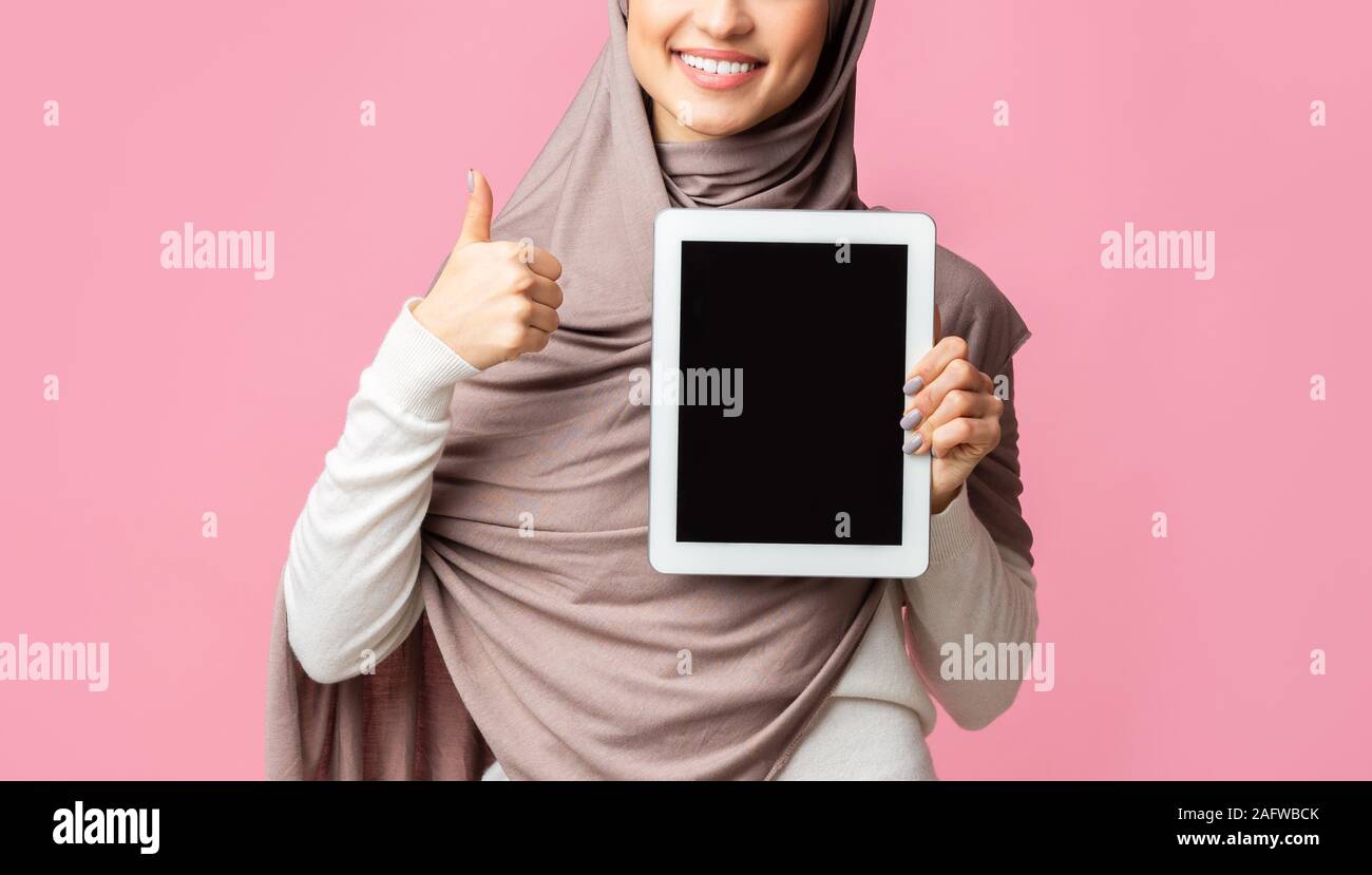 Muslim girl in headscarf demonstrating digital tablet with black screen ...