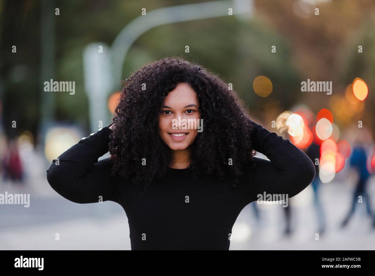 Portrait confident young woman on urban sidewalk Stock Photo