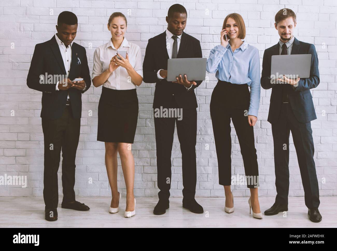 Diverse team with tablet pc, computers and smartphones Stock Photo