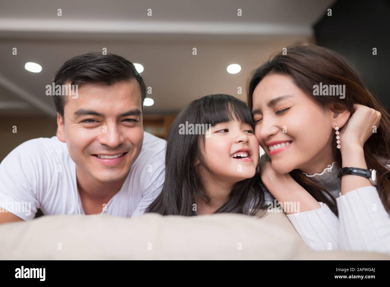 happy asian family spending time together on sofa in living room. family and home concept Stock Photo