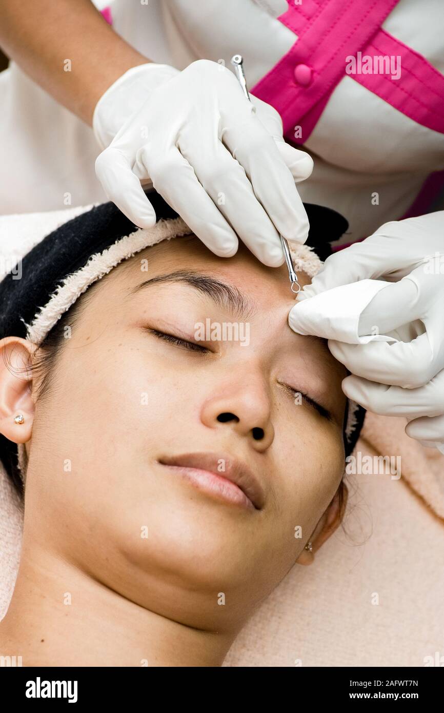 Closeup face of pretty Southeast Asian young woman having facial treatment  by beautician. Removing blackhead which clog the pores Stock Photo - Alamy