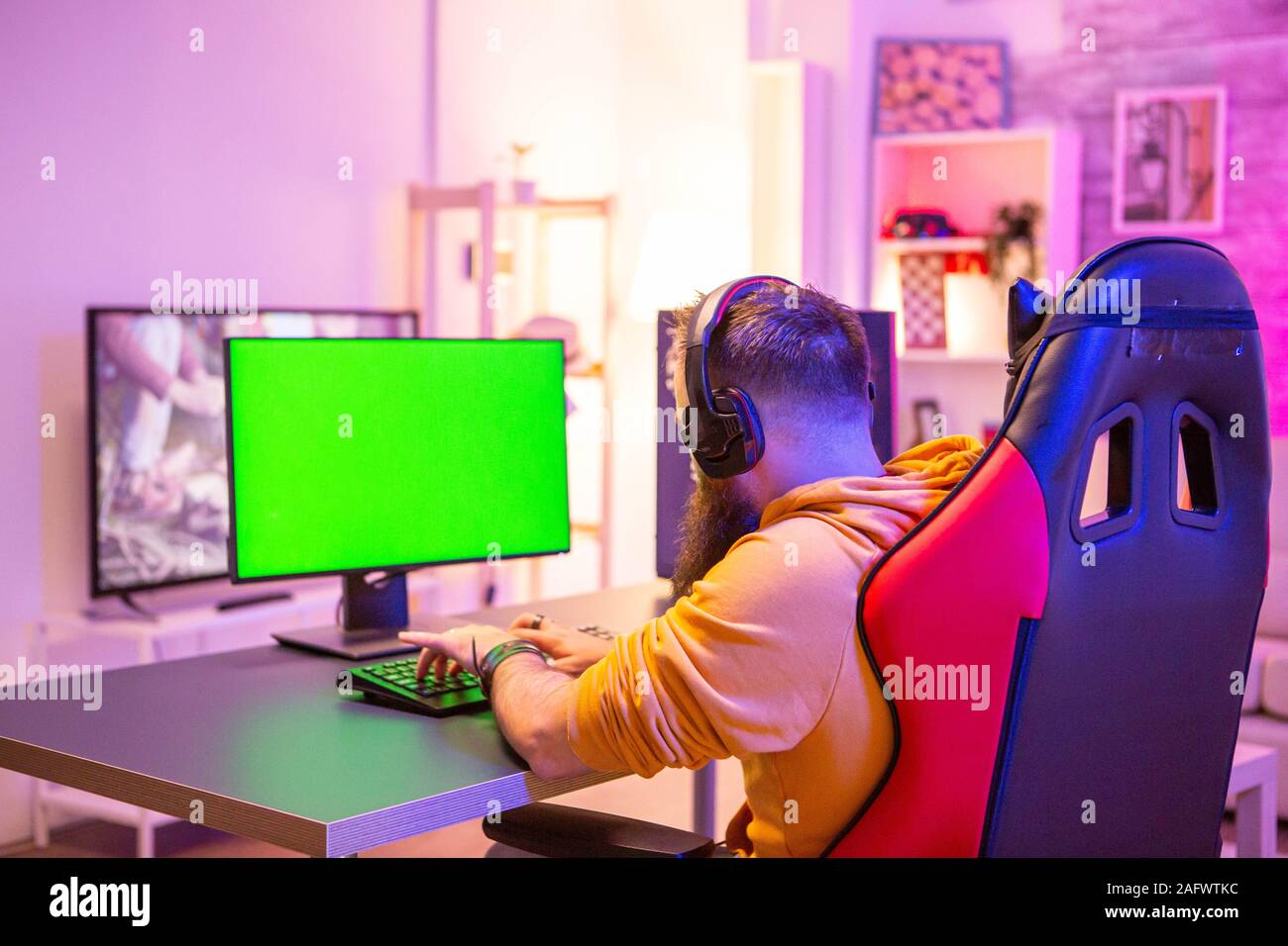 Man Playing On Powerfull Gaming Pc In A Room With Neon Lights On A