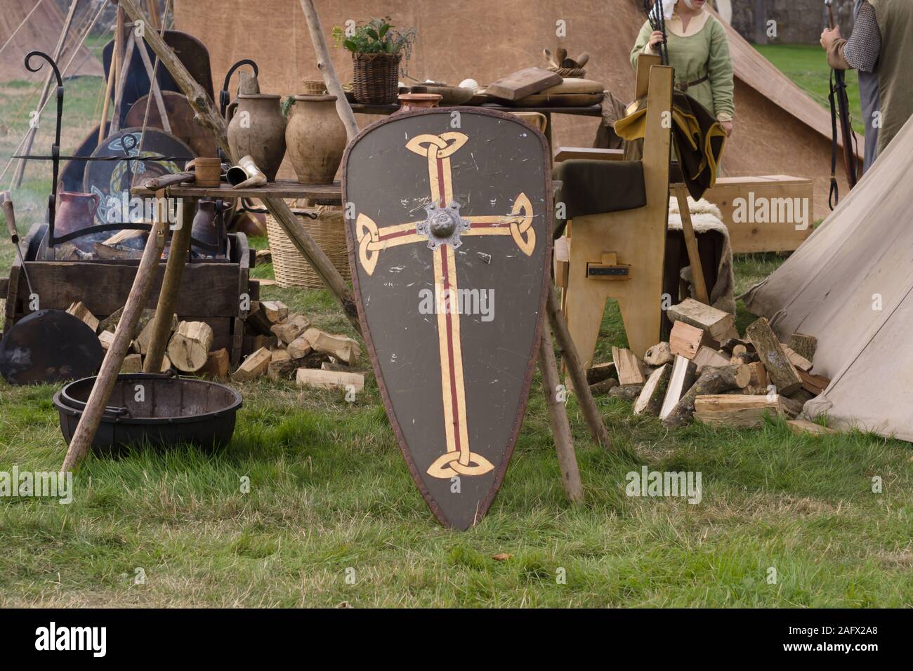 A replica of a typical medieval camp with table and utensils and a kite shield in the UK Stock Photo