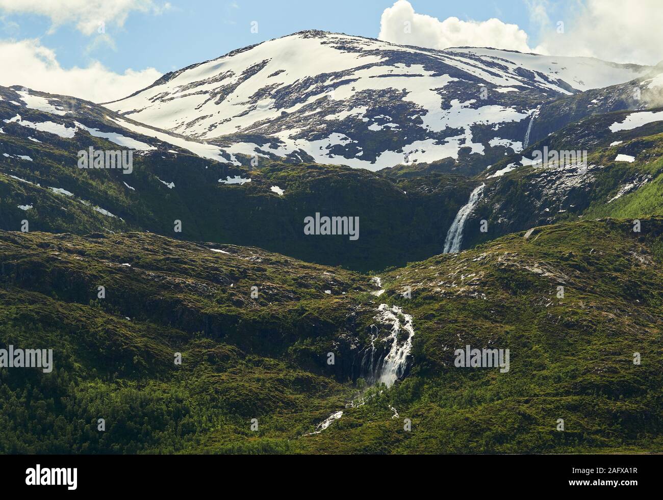 Northern landscape with  mountains and forest at the foreground and mountain peak and waterfall on the background. Senja Island, Troms County, Norway. Stock Photo