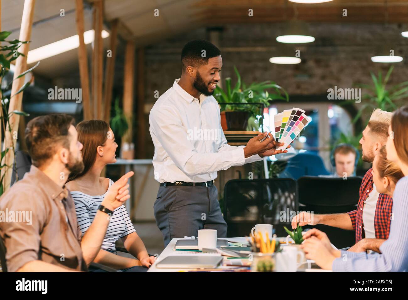 Young team choosing colors for new project, discussing work Stock Photo