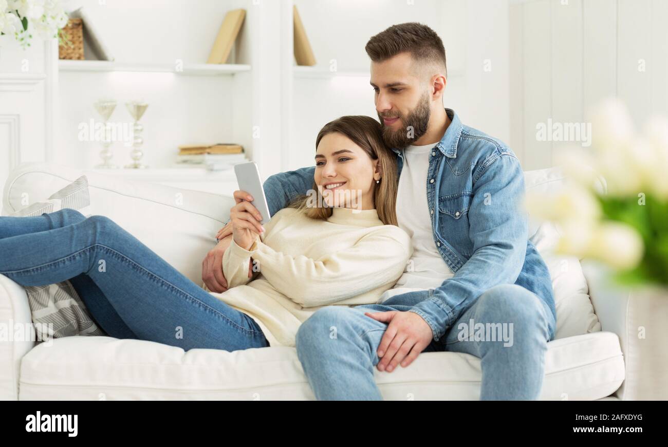 Happy couple in love using smartphone together Stock Photo