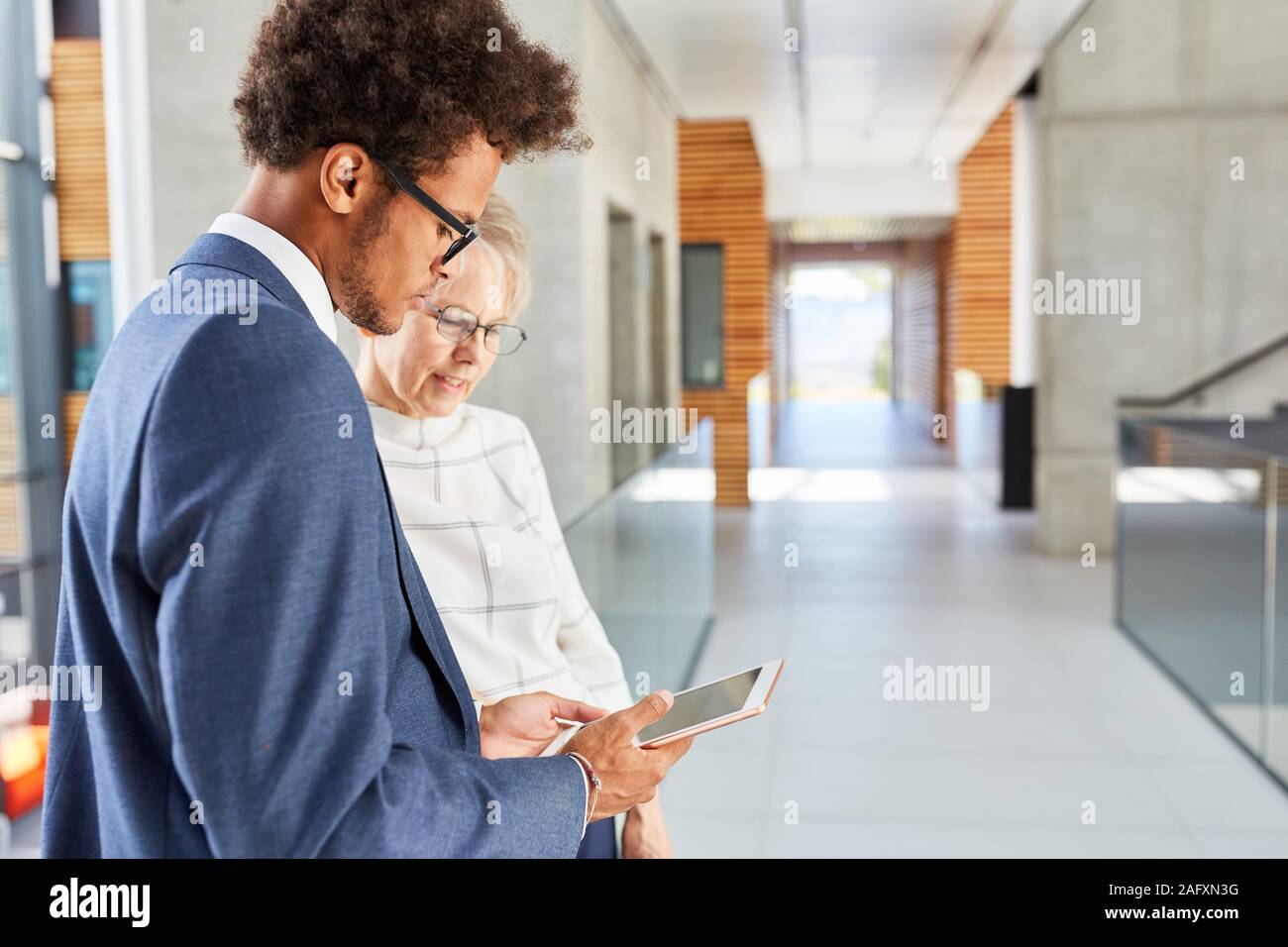 Two business people researching the Internet on a tablet computer Stock Photo