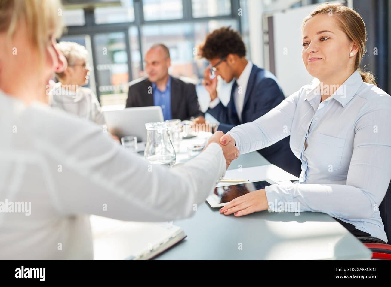 Two businesswomen handshaking in a negotiation or meeting Stock Photo