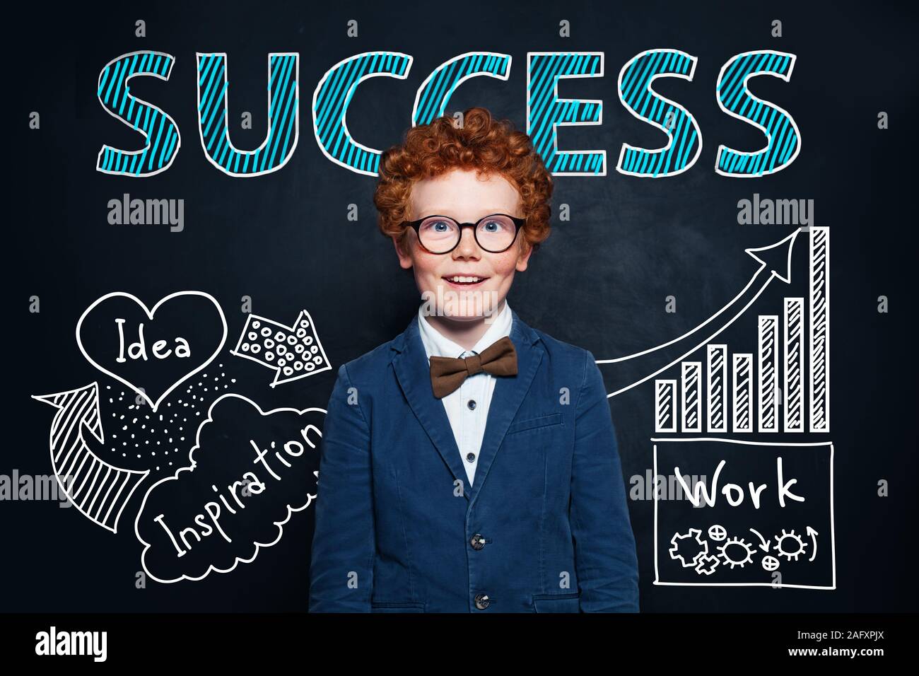 Redhead little boy in glasses and suit against hand drawing sketch and success text. Business idea and success concept Stock Photo