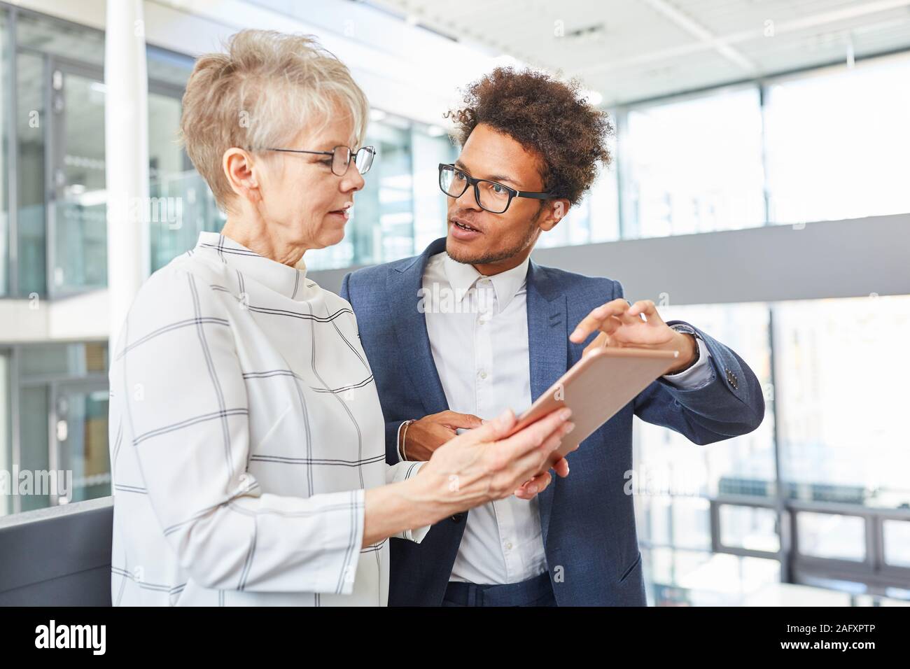 Software developer explains the new website design on the tablet to his boss Stock Photo