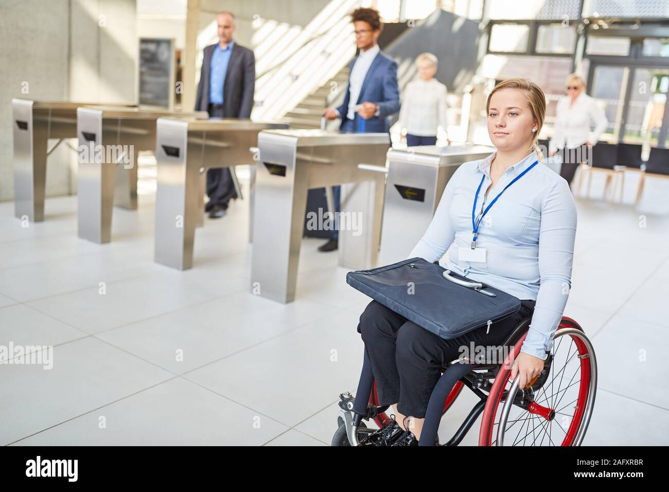 Young businesswoman in wheelchair on the way to the office with access control Stock Photo