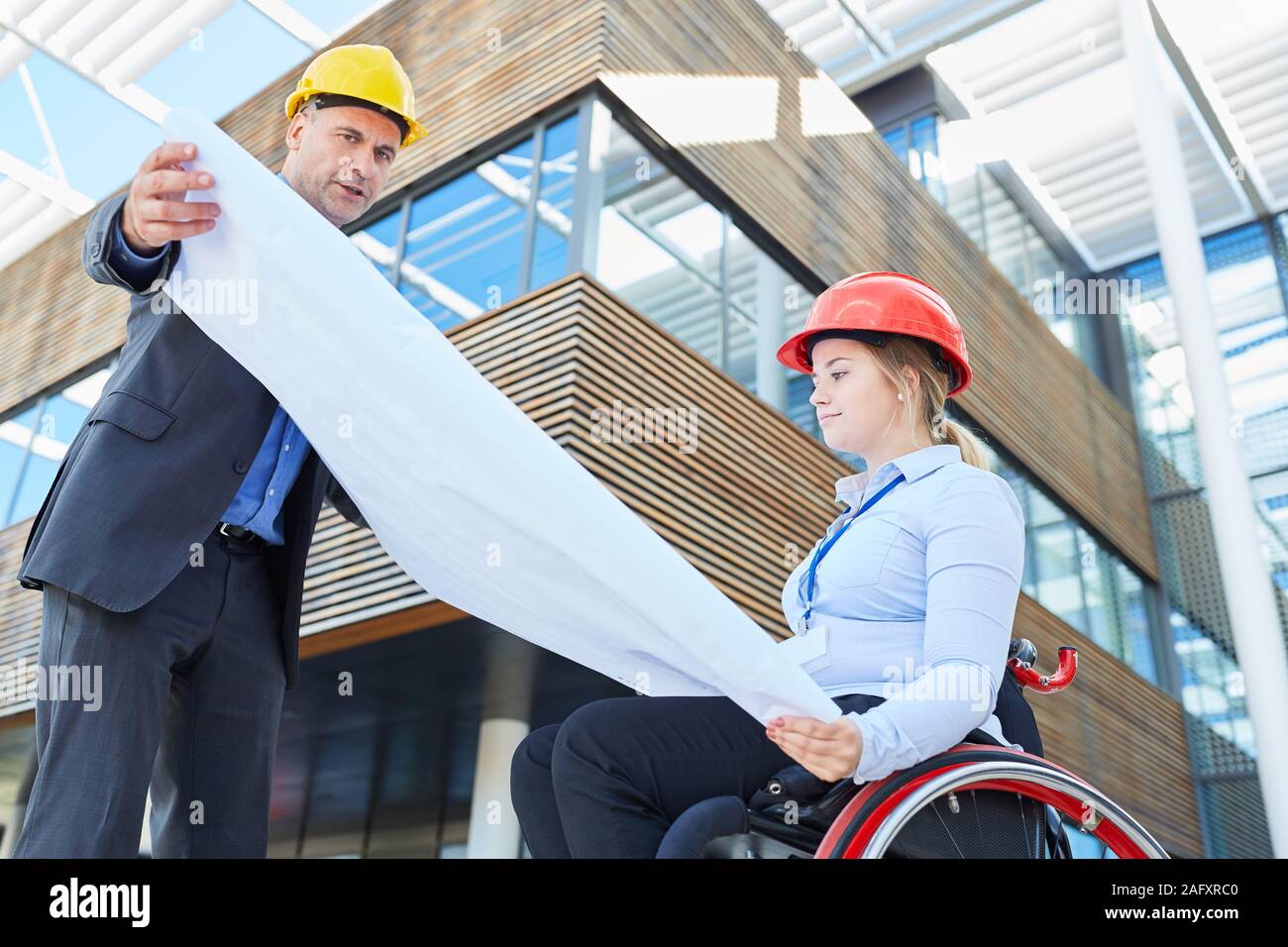Young woman as architect or construction manager with architectural drawing in front of an office building Stock Photo