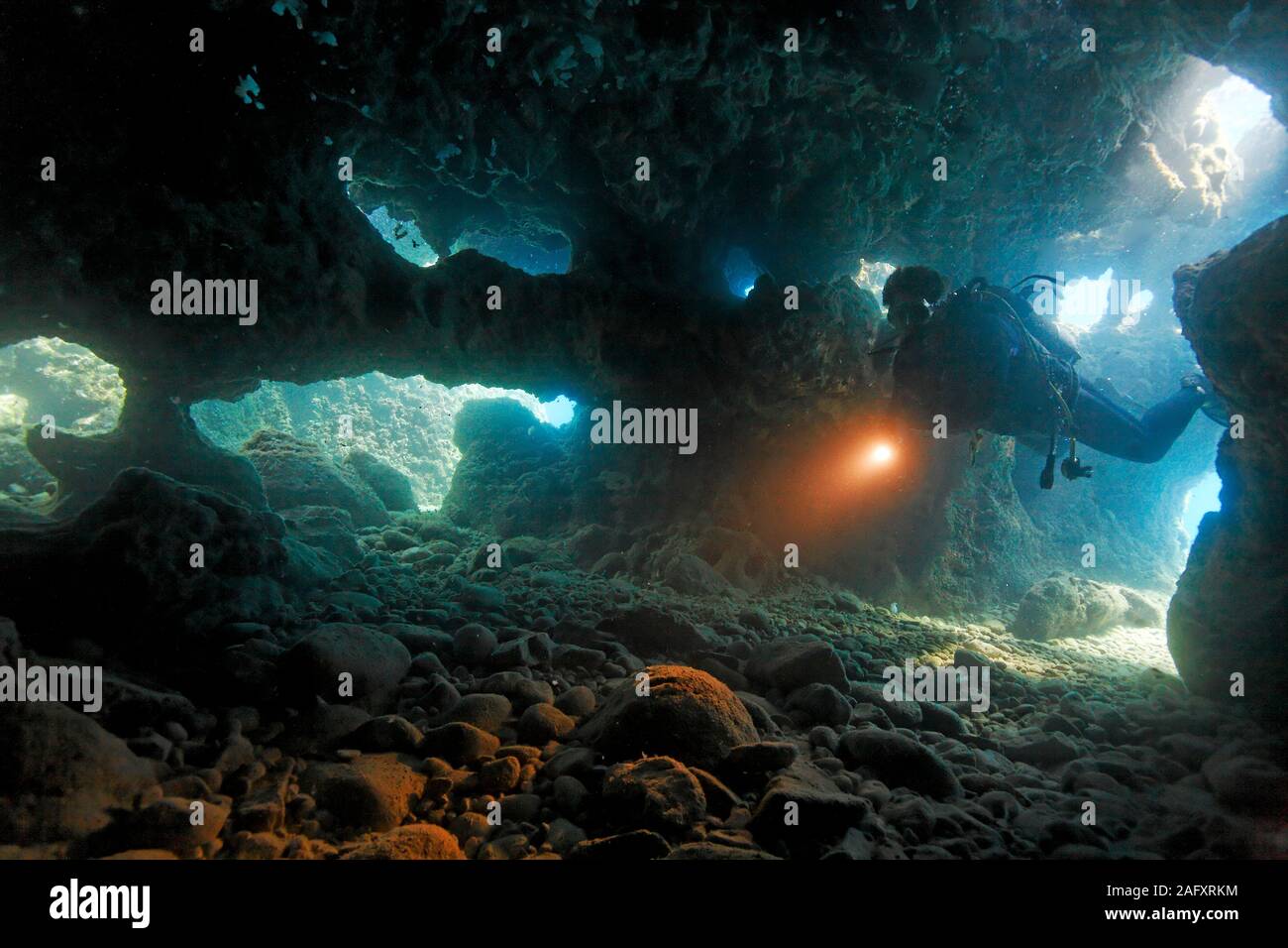 Taucher dringt in eine Unterwasserhöhle ein, Zakynthos, Griechenland | Scuba diver entering a underwater cave, Zakynthos island, Greece Stock Photo