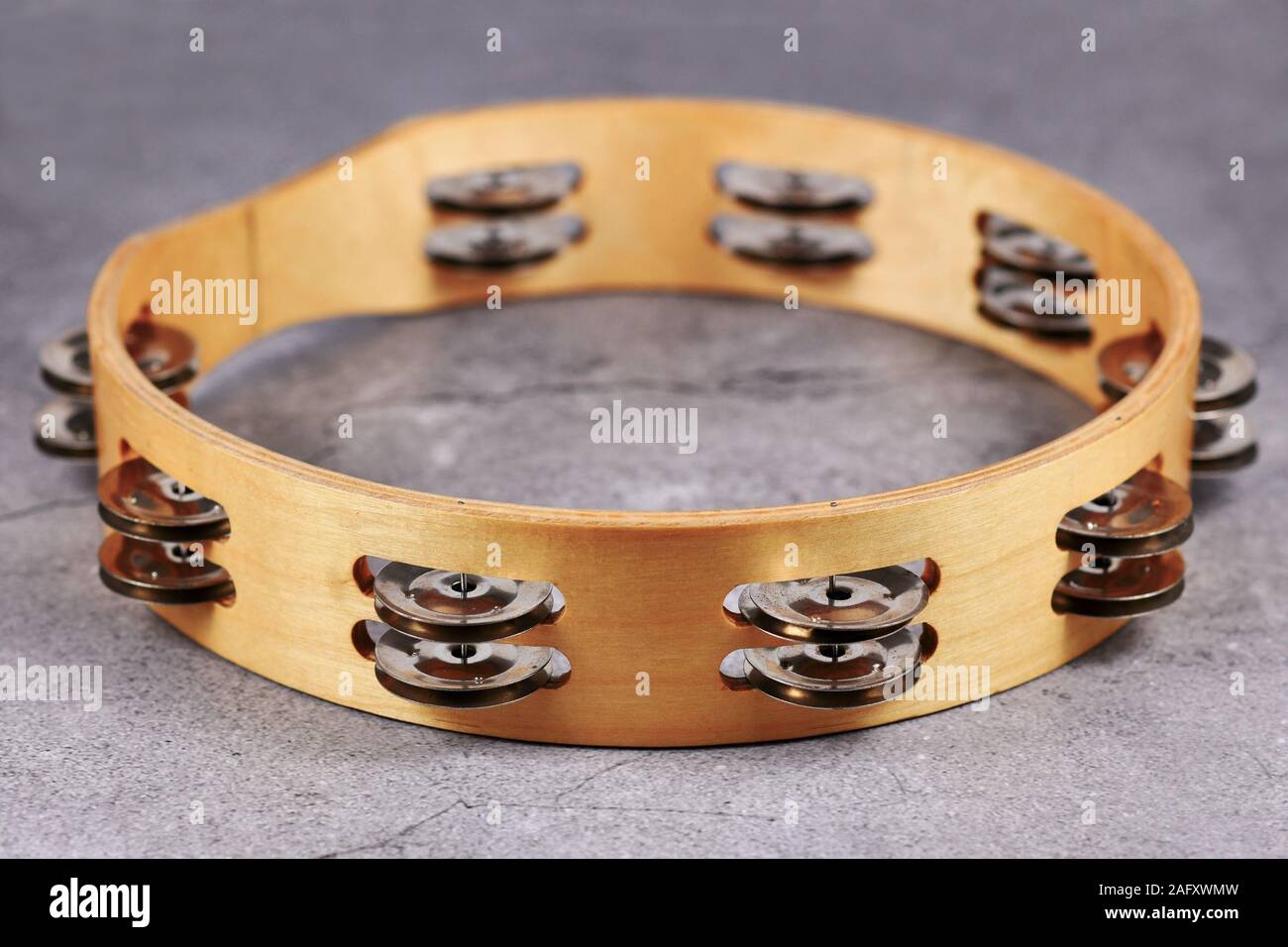Tambourine percussion music instrument with small metal jingles called 'Zills' on gray background Stock Photo