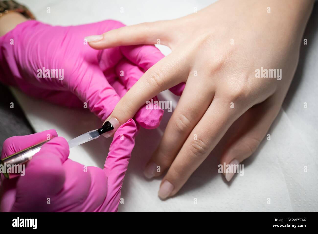 Professional manicurist applying nail polish. Stock Photo