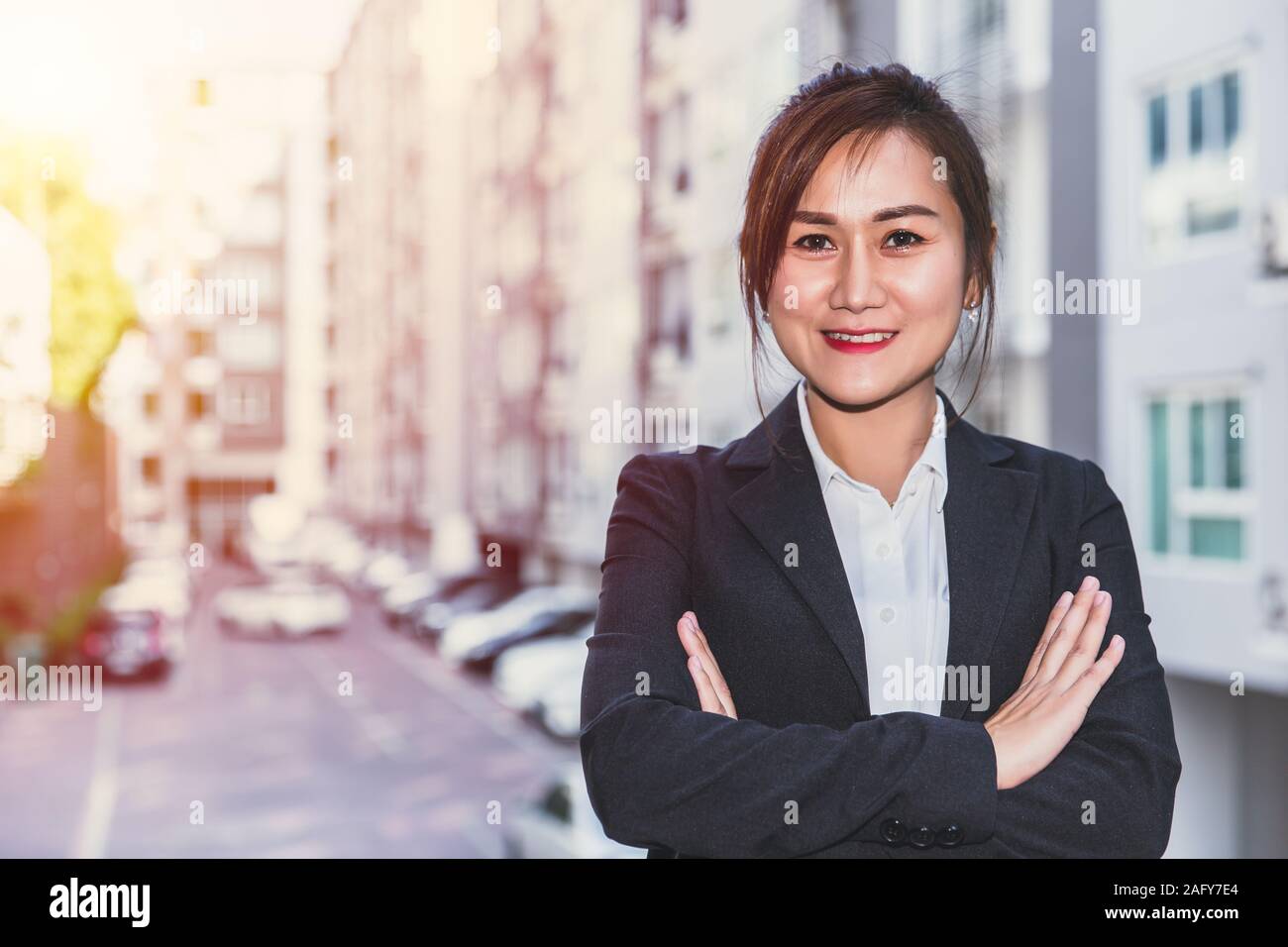 Real estate sale agency woman  portrait with condominium accommodation blur background for home asset business advertising. Stock Photo