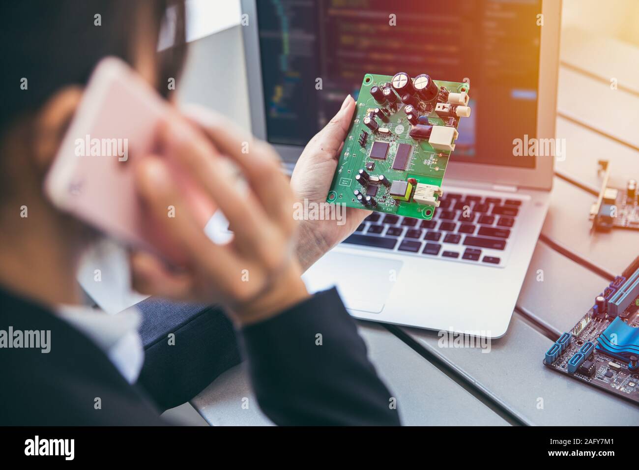 Electronic hardware engineer business person calling with chip supplier about digital circuit board product design. Stock Photo