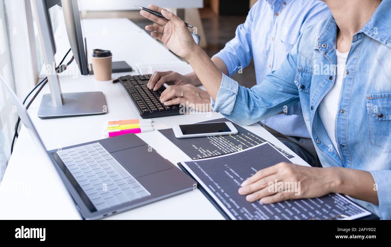 Young startup Programmers Sitting At Desks Working On Computers screen for Developing programming and coding to find solution to problem on New Applic Stock Photo