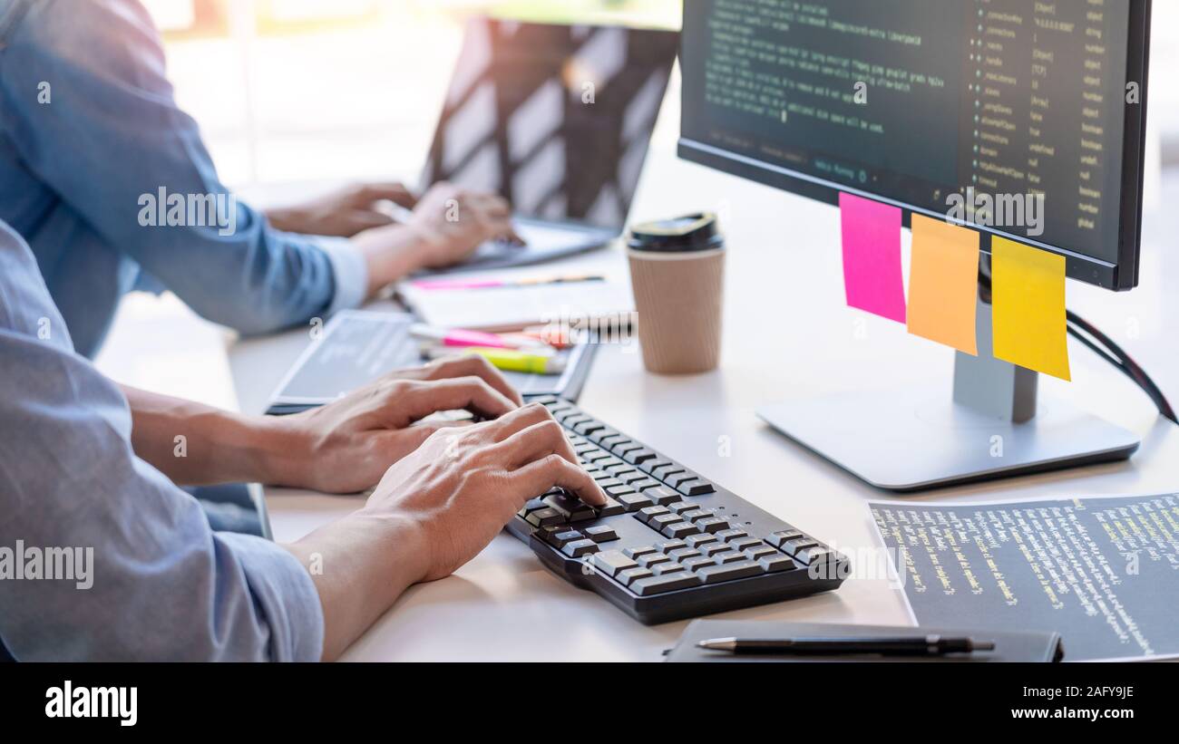 Young startup Programmers Sitting At Desks Working On Computers screen for Developing programming and coding to find solution to problem on New Applic Stock Photo