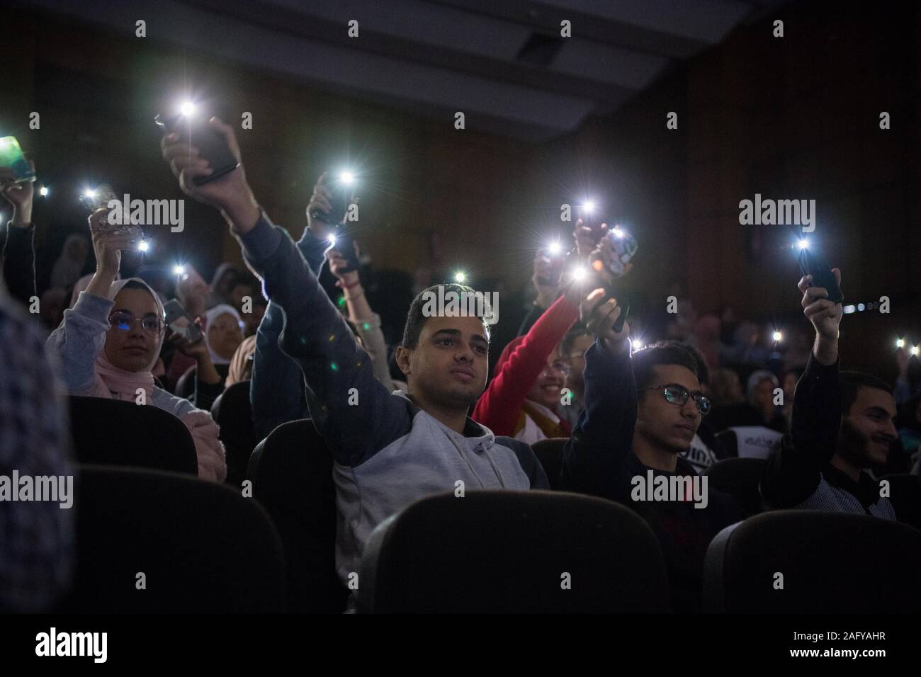 (191217) -- ISMAILIA, Dec. 17, 2019 (Xinhua) -- People wave their cellphones as they watch a contest of dubbing films in the Chinese language held in Ismailia Province, Egypt, on Dec. 16, 2019. The Confucius Institute at the Suez Canal University of Egypt has hosted a contest of dubbing films in the Chinese language among the Egyptian university students. TO GO WITH 'Egyptian students compete in first contest of dubbing Chinese films' (Xinhua/Wu Huiwo) Stock Photo
