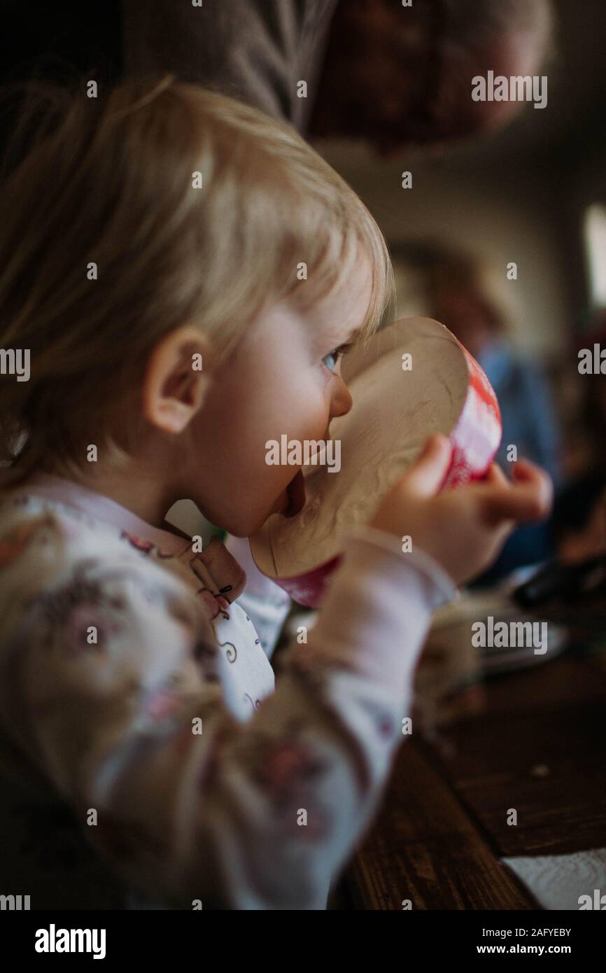 toddler licking the top of ice cream container Stock Photo
