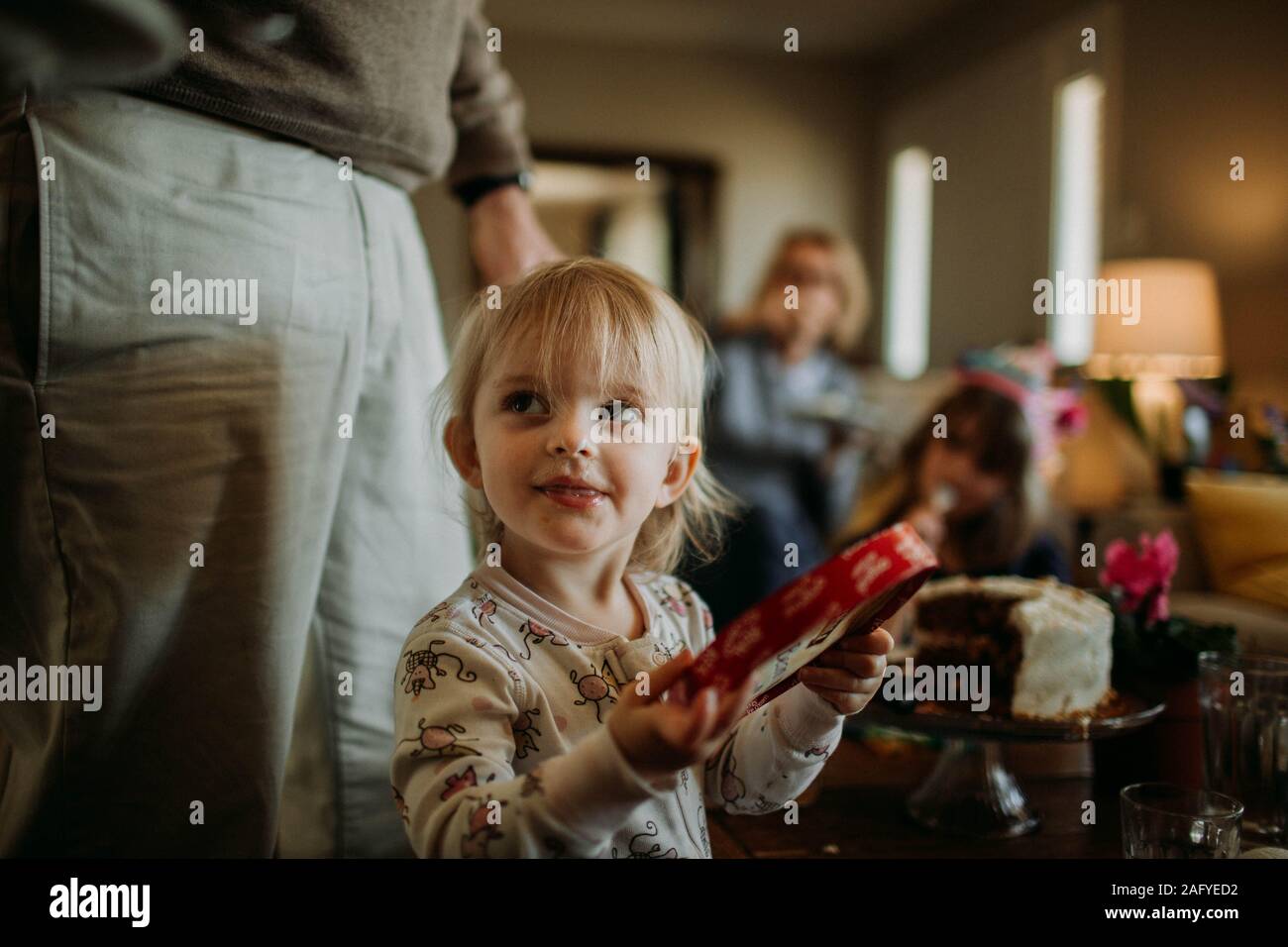 toddler in pajamas at family gathering with mischievous smile Stock Photo