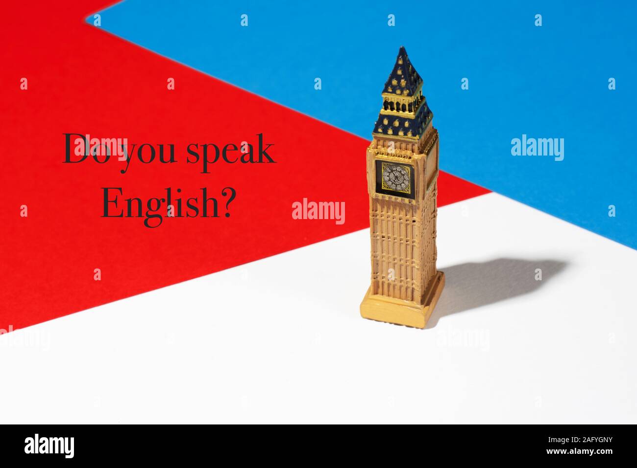 a miniature of the Big Ben Tower of London on a background with the colors of the flag of the United Kingdom, and the question do you speak English Stock Photo