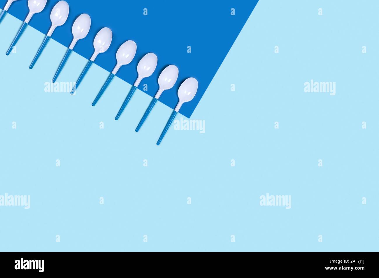 Dangerous plastic spoons. Environmental problem of plastic rubbish