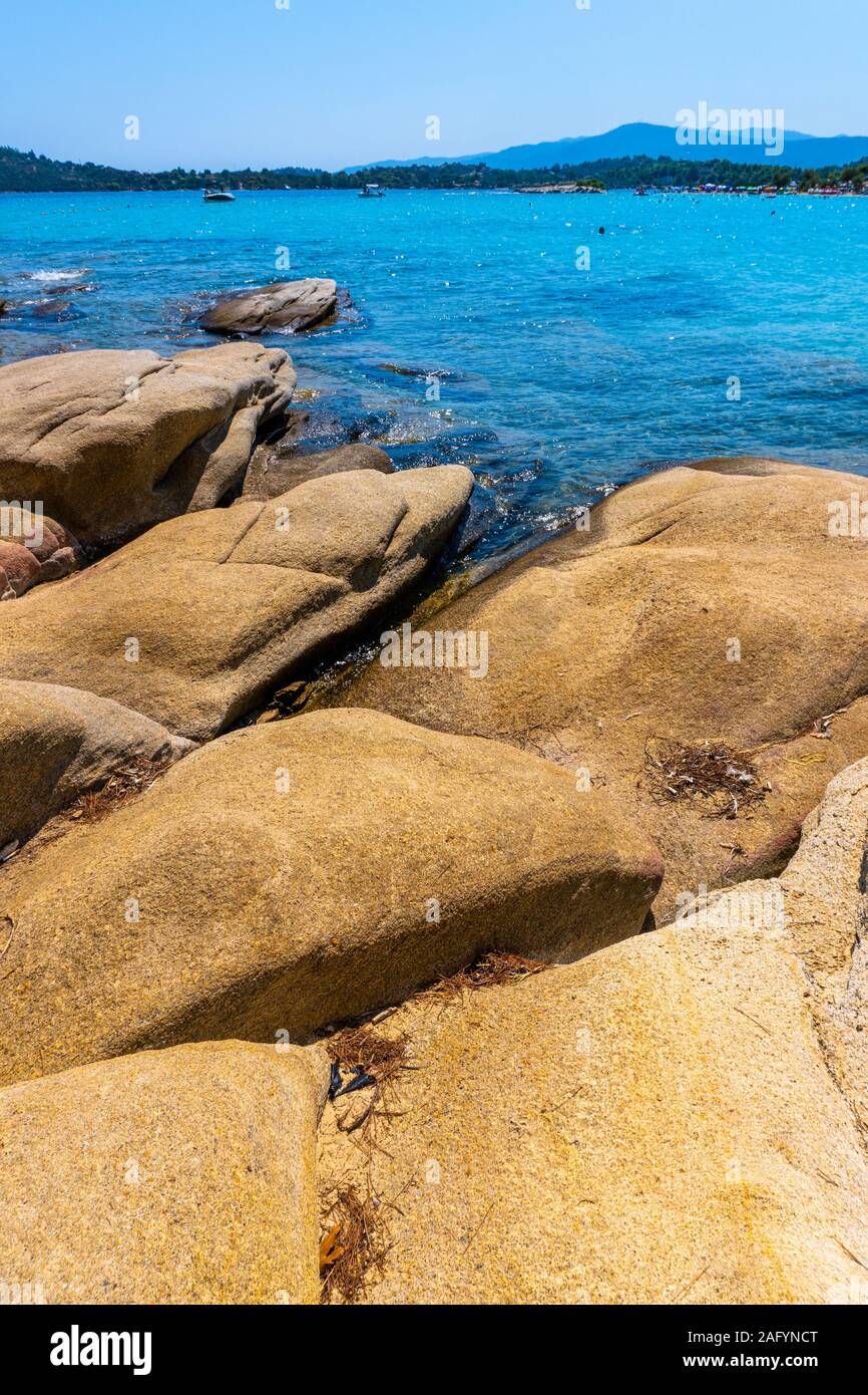 Yellow stones against the sea in Greece vertical Stock Photo