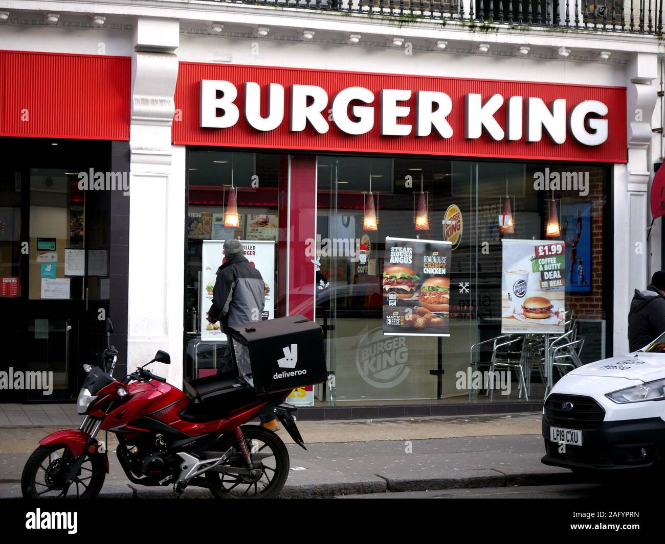 Burger King in Queensway London with deliveroo moped outside Stock