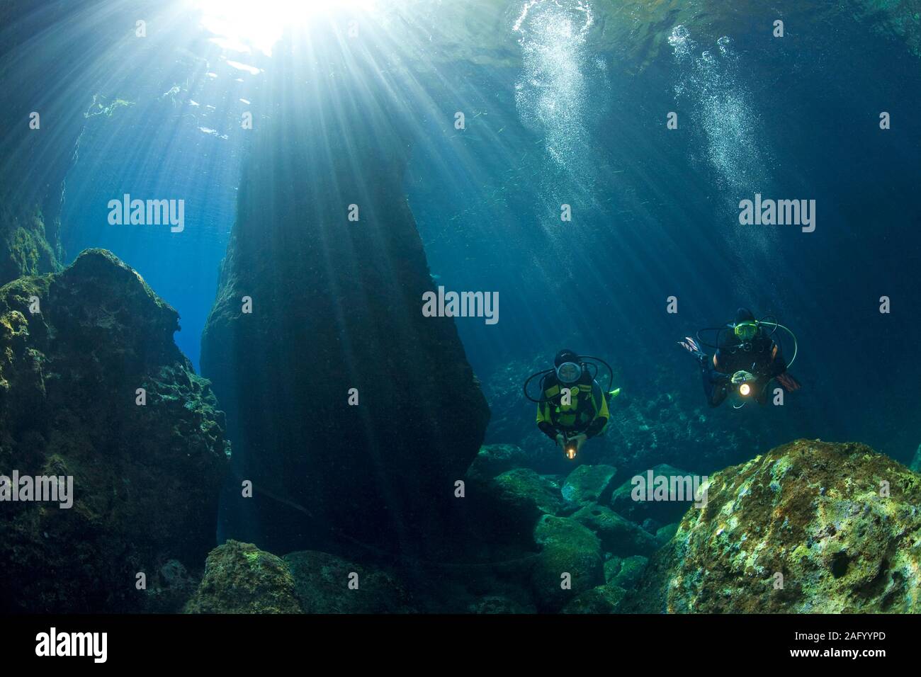 Scuba diver in a rocky mediterranean reef flooded with sunlight, Zakynthos, island, Greece Stock Photo
