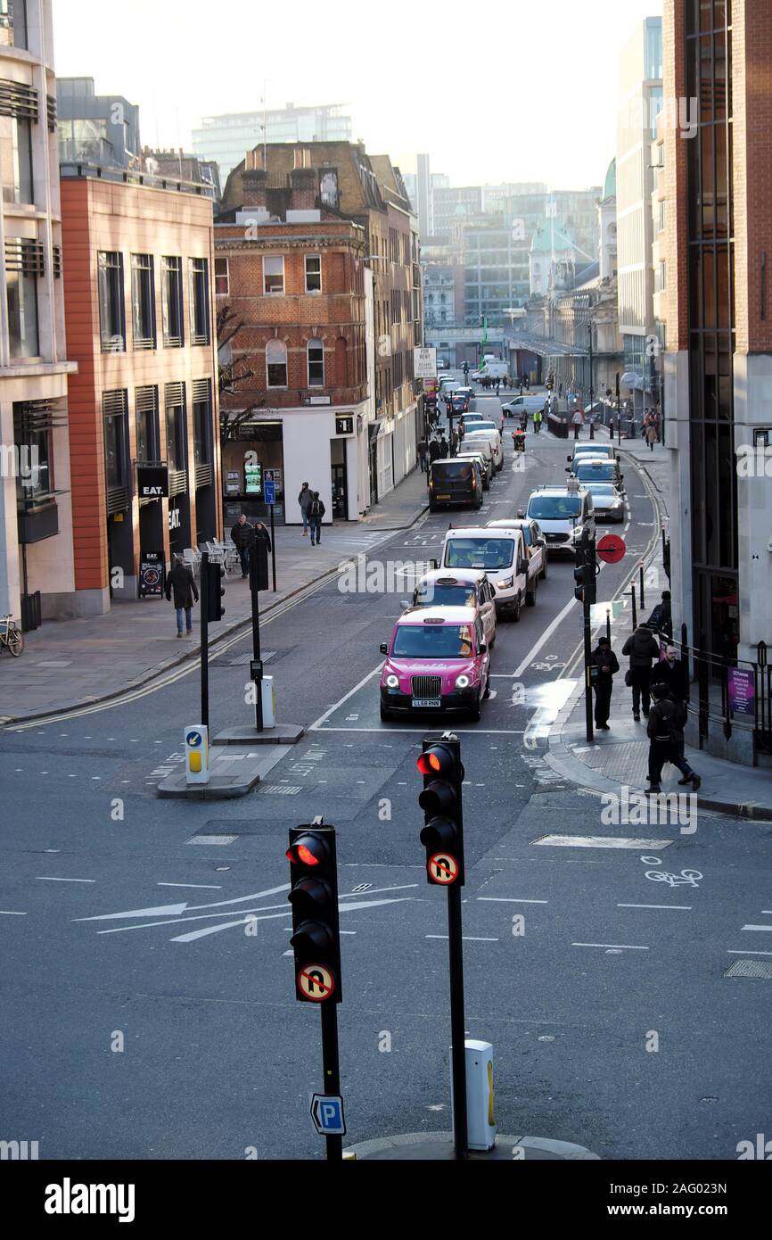 Pink taxi cab waiting for traffic lights to change view of Long Lane on corner of Goswell St looking towards Smithfield Market London UK  KATHY DEWITT Stock Photo