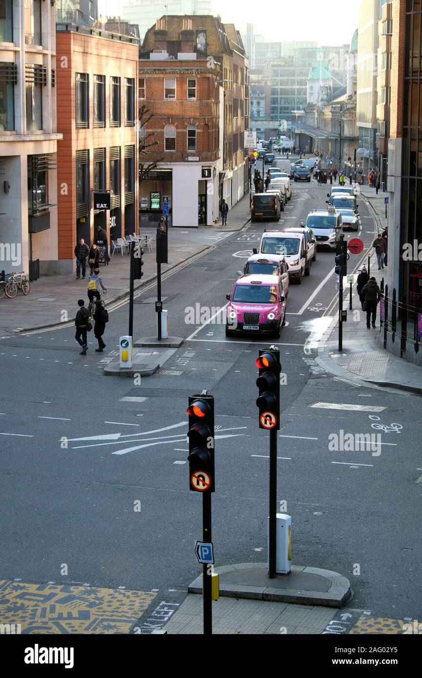 Pink taxi cab waiting for traffic lights to change view of Long Lane on corner of Goswell St looking towards Smithfield Market London UK  KATHY DEWITT Stock Photo