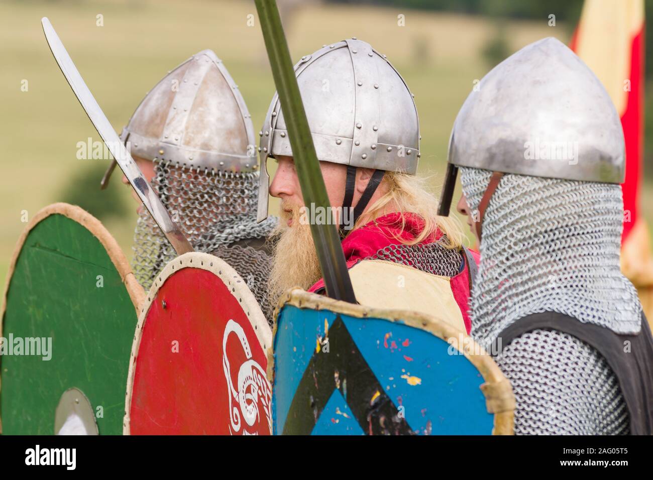 Medieval battle re-enactment with men dressed in chain mail and helmets armed with swords and shields Stock Photo