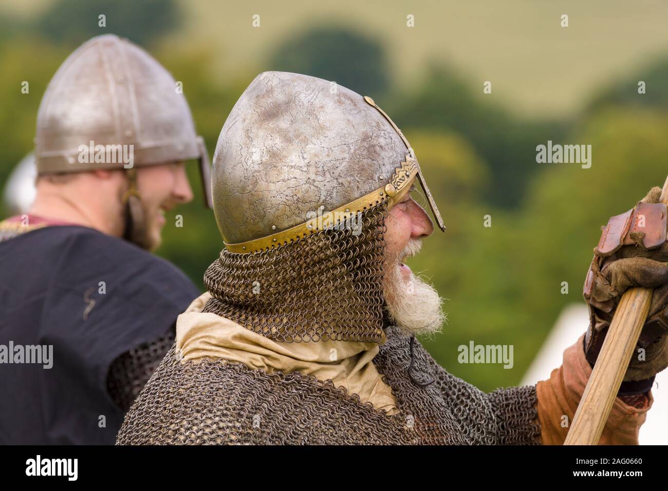 Medieval battle re-enactment with men wearing a cervelliere or skull cap helmet and chain mail aventail or camail to protect the neck Stock Photo