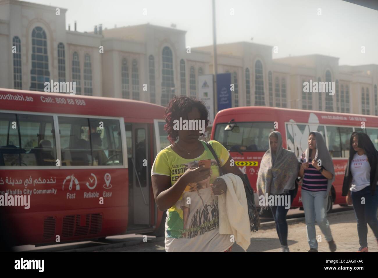 Multi-ethnic girls dropping off by the Khalifa City Free Bus Service in Abu Dhabi, UAE Stock Photo