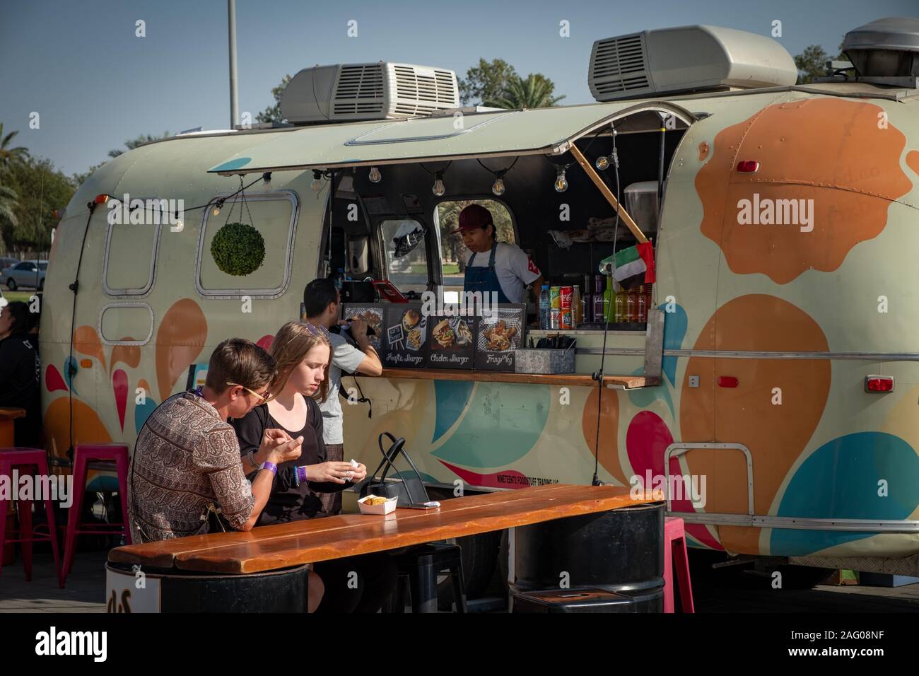 Western couple enjoying snacks in a warm day in-front of the food truck Stock Photo