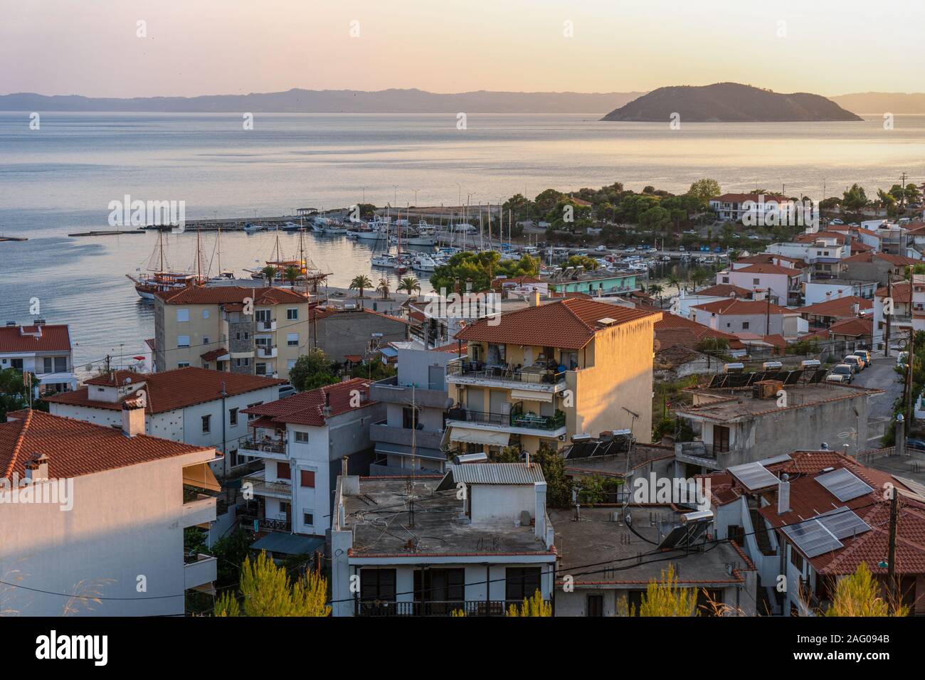 Red roofs of houses and a rock in the sea in Greece aerial view horizontal Stock Photo