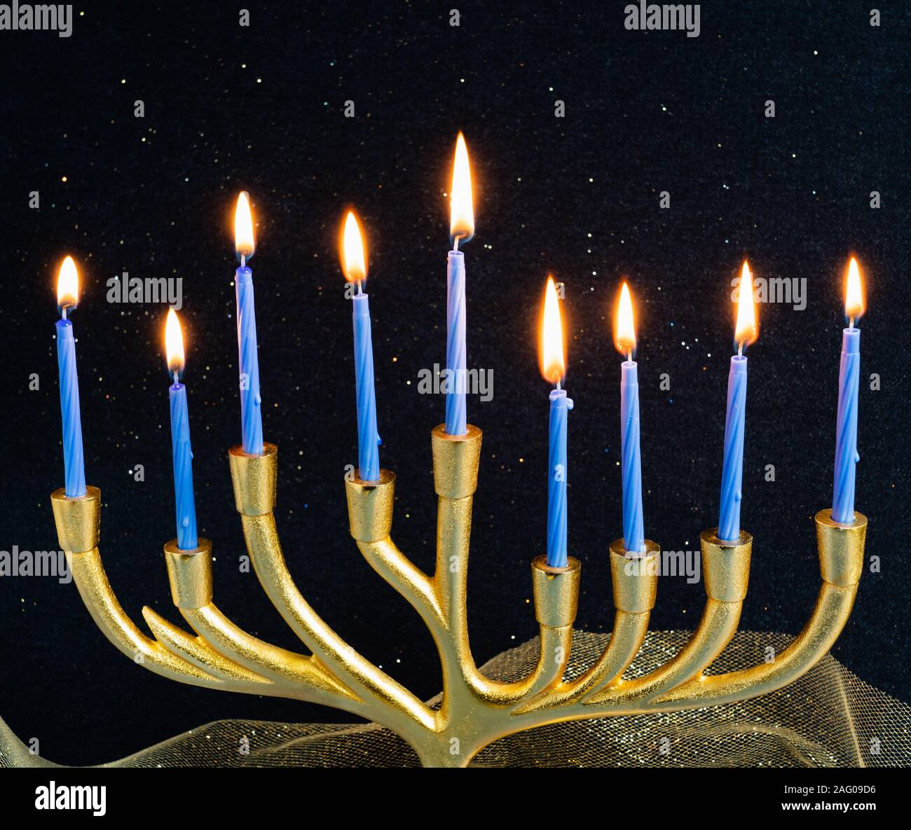 golden menorah with nine blue candles signifying the eight flames and