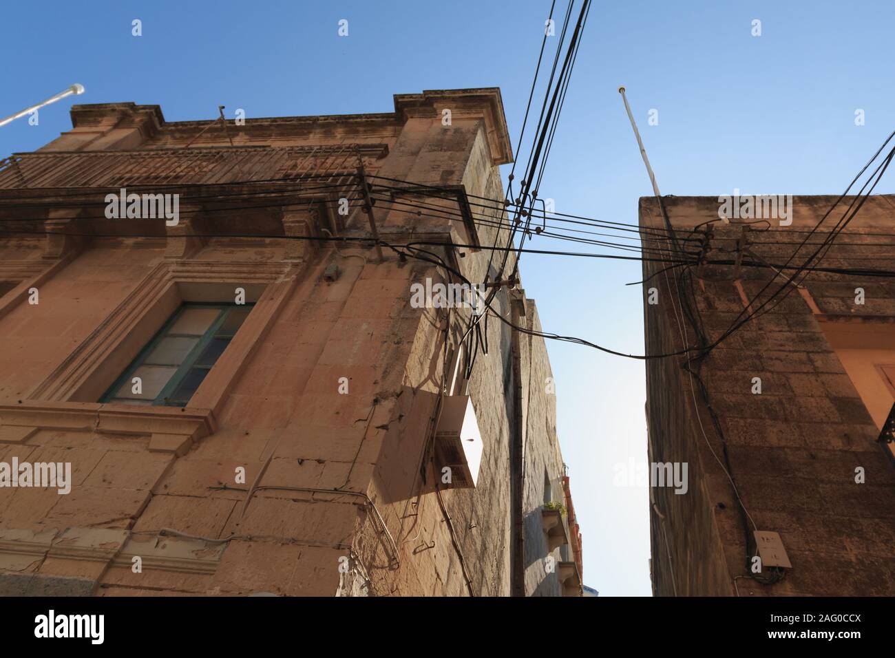 Messy electrical cables on buildings in Malta view upwards Stock Photo