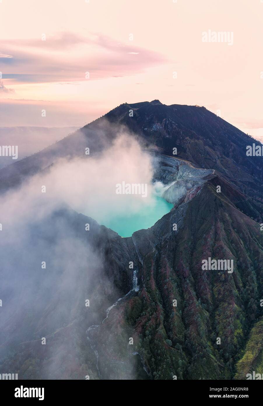 Stunning sunrise over the Ijen volcano with the beautiful turquoise-coloured acidic crater lake. The Ijen volcano complex is a group of composite volc Stock Photo