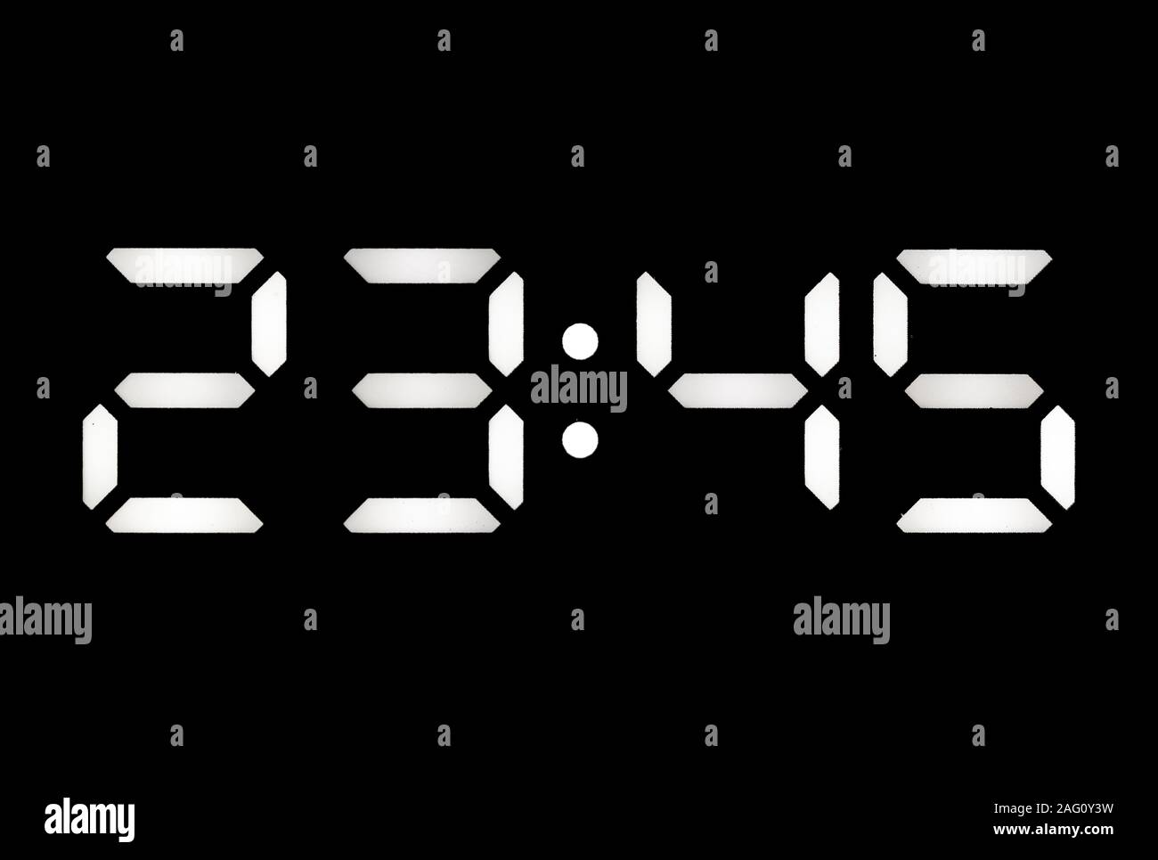 Real white led digital clock on a black background showing time 23:45 Stock Photo