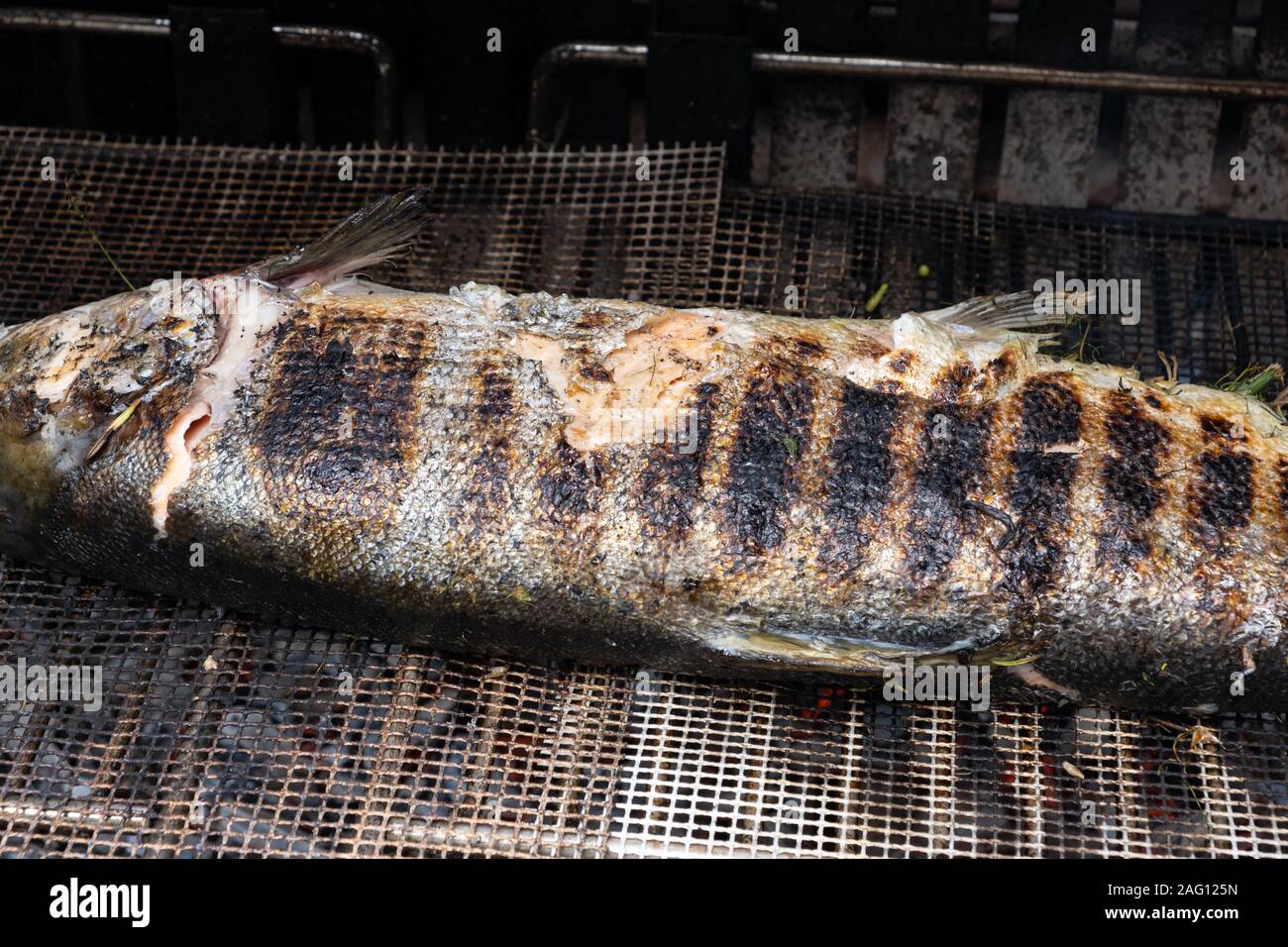 salmon stuffed with herbs grilling on the barbecue Stock Photo