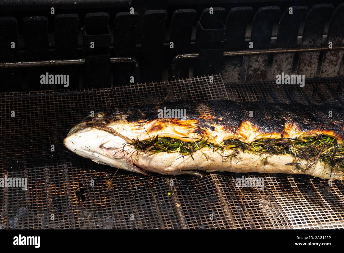 salmon stuffed with herbs grilling on the barbecue Stock Photo